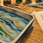 Marbrure sur papier : motifs flottants au bain bleu sur feuille aquarelle